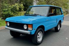 a blue land rover is parked on the street