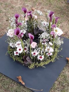 an arrangement of flowers on a mat in the grass