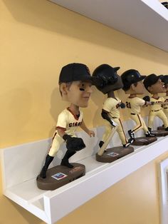 some baseball figurines are lined up on a shelf