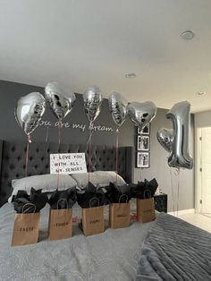 balloons and gift bags on a bed in a room with a sign that says, you are my dream