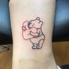 a small tattoo of a bear holding a heart