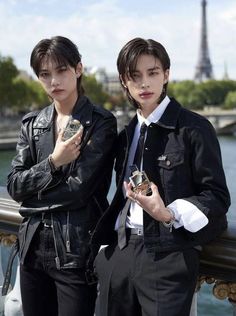 two young men standing next to each other in front of the eiffel tower