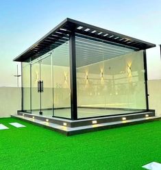 a glass building sitting on top of a lush green field