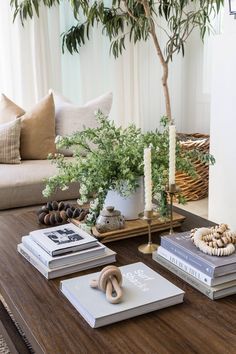 a coffee table topped with books and candles