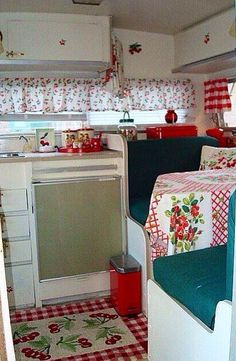 the inside of a camper with red and white checkered tablecloth on it