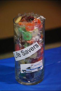 a glass filled with gummy bears sitting on top of a blue table