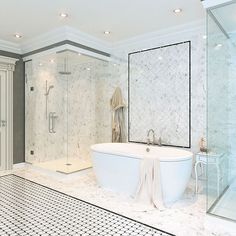 a bathroom with marble walls and flooring, including a large bathtub in the center