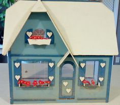 a blue doll house with hearts on the windows