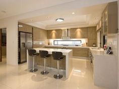 a large kitchen with three bar stools in it