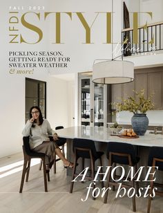 a woman sitting at a kitchen table in front of a magazine cover with the title, home for hosts