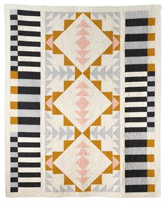 an orange, black and white quilt with geometric designs