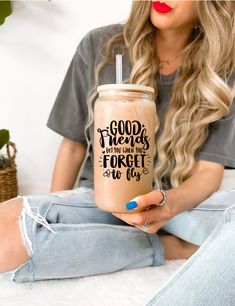 a woman sitting on the floor holding a drink