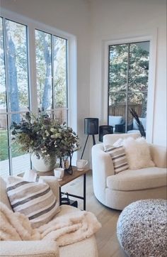 a living room filled with furniture and large windows