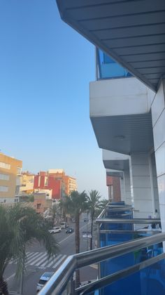 a balcony with palm trees and buildings in the background