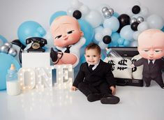 a little boy sitting in front of some balloons