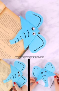 an elephant cut out of paper sitting on top of a book with its trunk sticking out