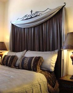 a bed with two lamps on either side of it and a canopy over the headboard