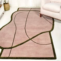 a living room with a pink rug and chair