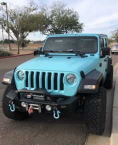 a blue jeep is parked on the side of the road