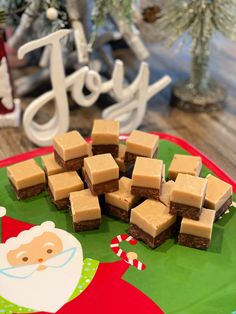 there are many pieces of brownies on the plate next to christmas decorations and trees