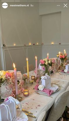 a table set for a wedding with candles and napkins on top of the table