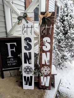 two wooden signs sitting next to each other in the snow