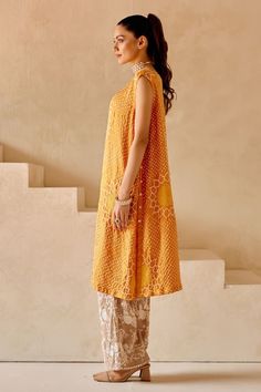 Orange shift dress kurta with sunflower patterns in crushed bandhani work and side button down panels. - Aza Fashions Unstitched Sleeveless Dress For Eid, Sleeveless Chanderi Dress With Mirror Work, Summer Chanderi Dress With Cutdana Detail, Sleeveless Chanderi Dress With Chikankari Embroidery, Traditional Sleeveless Dress With Chikankari Embroidery, Sleeveless Chikankari Chanderi Dress, Summer Cutdana Chanderi Dress, Sleeveless Dress With Dupatta For Eid, Sleeveless Mirror Work Dress For Eid