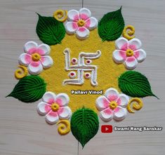 an embroidered design with flowers and leaves on a wooden surface in the shape of a circle