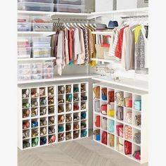 an open closet with lots of clothes and shoes on the shelves in front of it