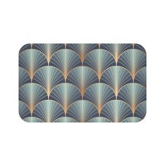 an art deco style bath mat with blue and gold fan design on it, in front of