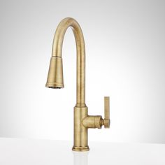 an antique brass faucet with two sprayers on the side and a white wall behind it