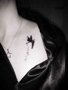 a black and white photo of a woman's chest with a star tattoo on it