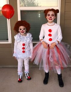 two children dressed up as clowns standing next to each other