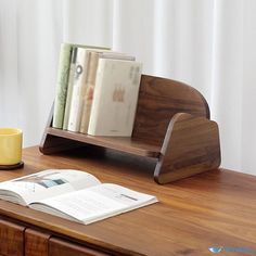 a wooden desk with books and a cup on it