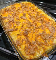 a casserole dish sitting on top of an oven with lots of toppings