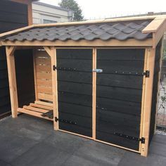 a wooden shed with two doors open on the roof and one door closed to another