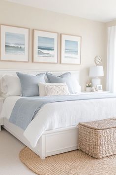 a bedroom with white and blue decor on the walls, carpeted flooring and pictures above the bed