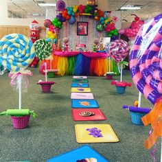 an office decorated for a birthday party with colorful decorations and candy on the floor, including lollipops