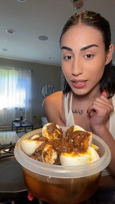 a woman holding a plastic container filled with food