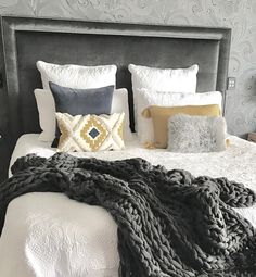 a bed with blankets and pillows on top of it