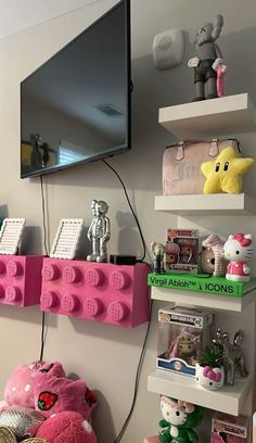 a tv mounted to the side of a wall next to shelves filled with stuffed animals