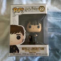 a harry potter pop vinyl figure in a box on a bed with the cover pulled down