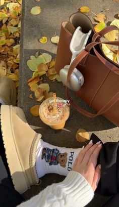 a person sitting on the ground next to a brown purse