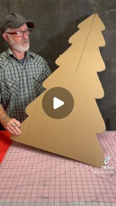 a man is making a cardboard christmas tree