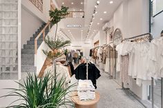 a woman is walking down the stairs in a clothing store