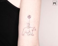 a woman's arm with a small tattoo of a bear and a balloon on it