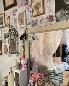 a bedroom decorated in pink and white with pictures on the wall