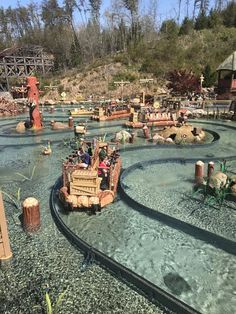 an amusement park filled with lots of water and people riding on roller coasters in the middle