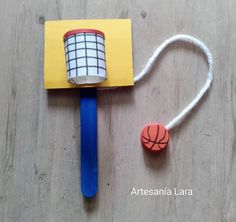 a piece of paper with a basketball on it next to a plastic ball and string