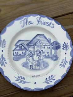 a blue and white plate with an image of two people standing in front of a house